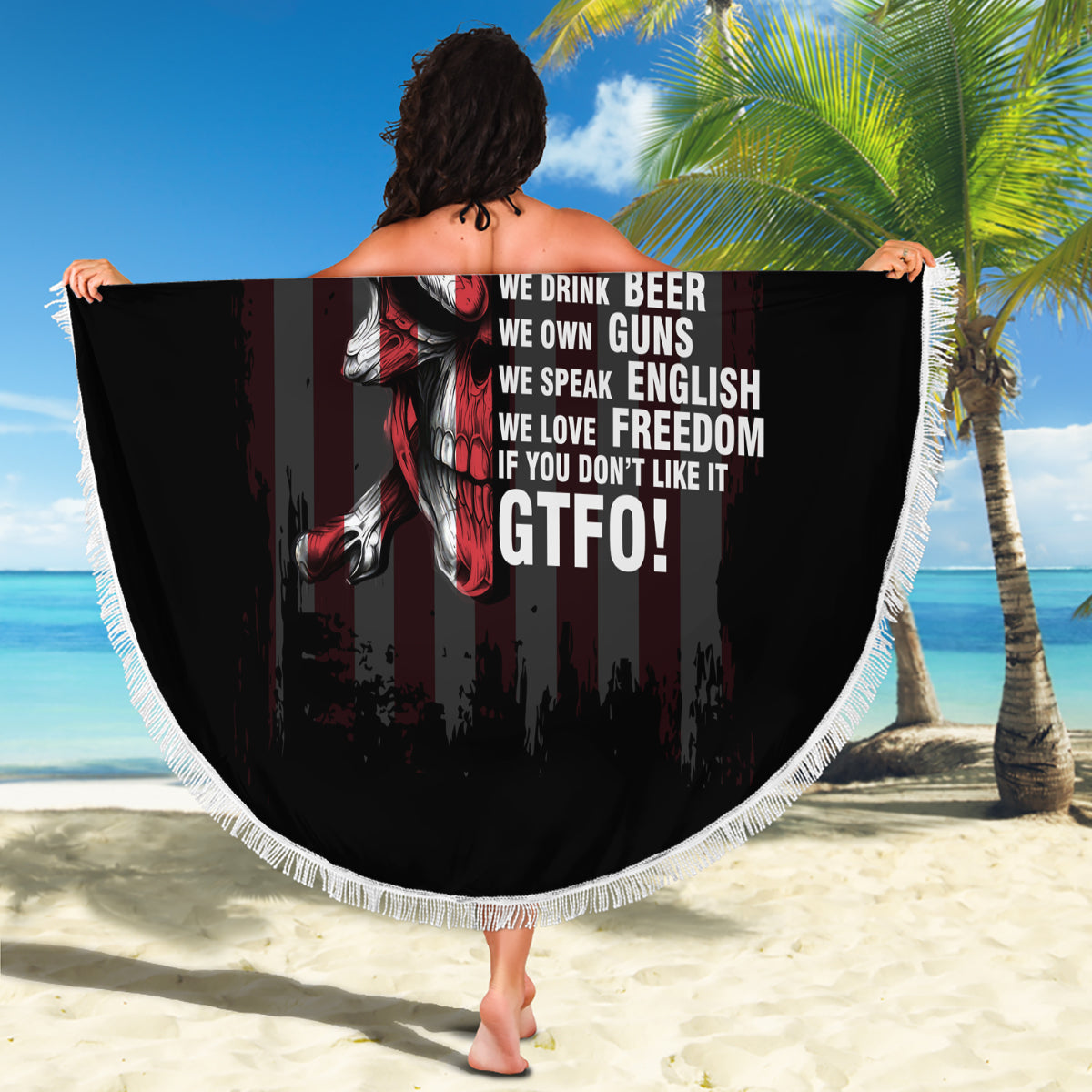 Round patriotic beach blanket with black skull-and-flag print, white fringe, bold text