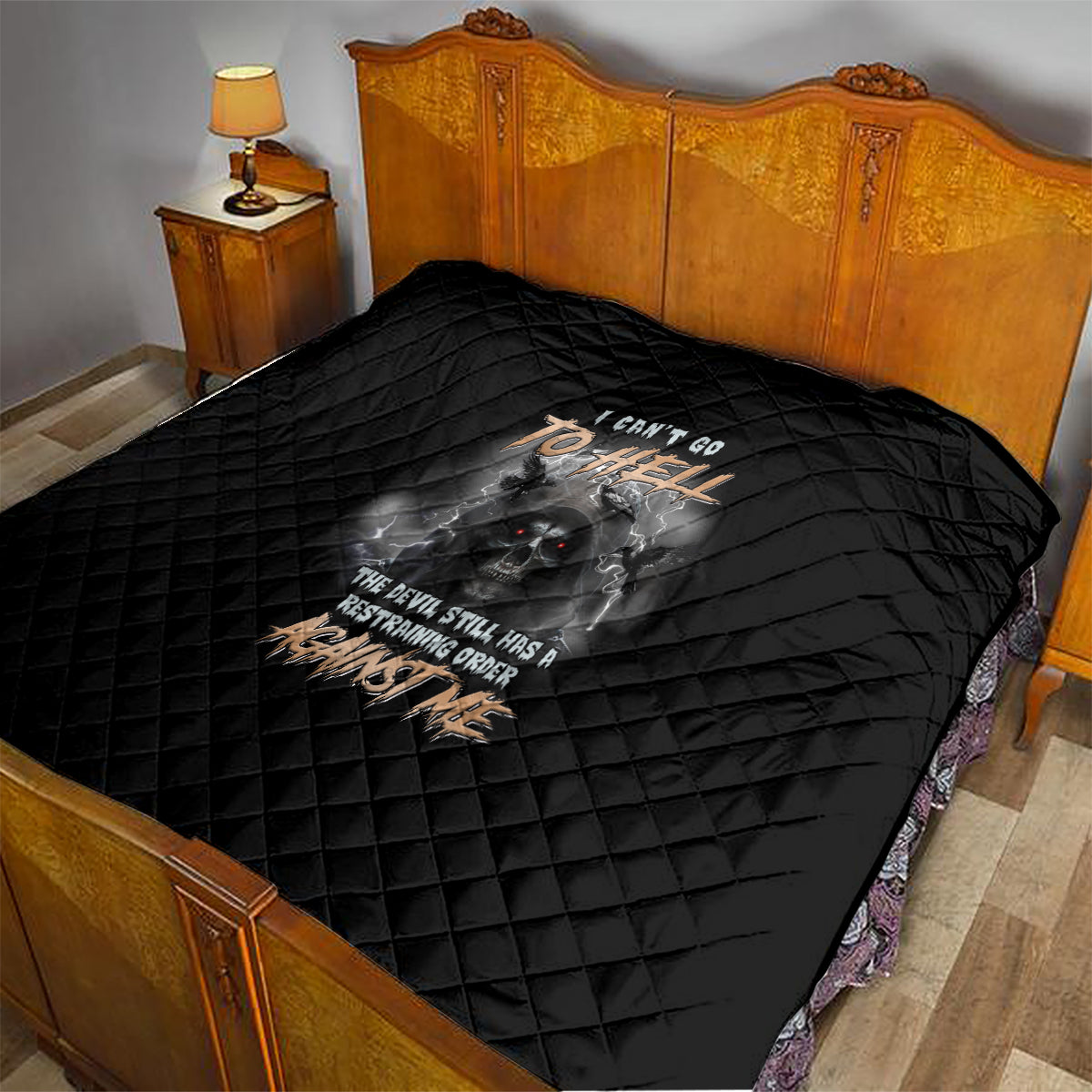 Black quilt draped over bed with diamond quilting and reaper skull graphic