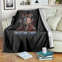Black graphic blanket with skull and “Trust Me I Will” text, on striped couch