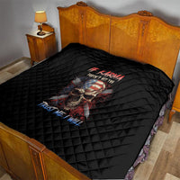 Black quilt blanket with skull graphic on bed, diamond quilt stitching visible