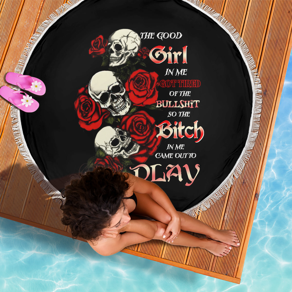 Round black beach blanket with skulls, red roses, and fringed white edge