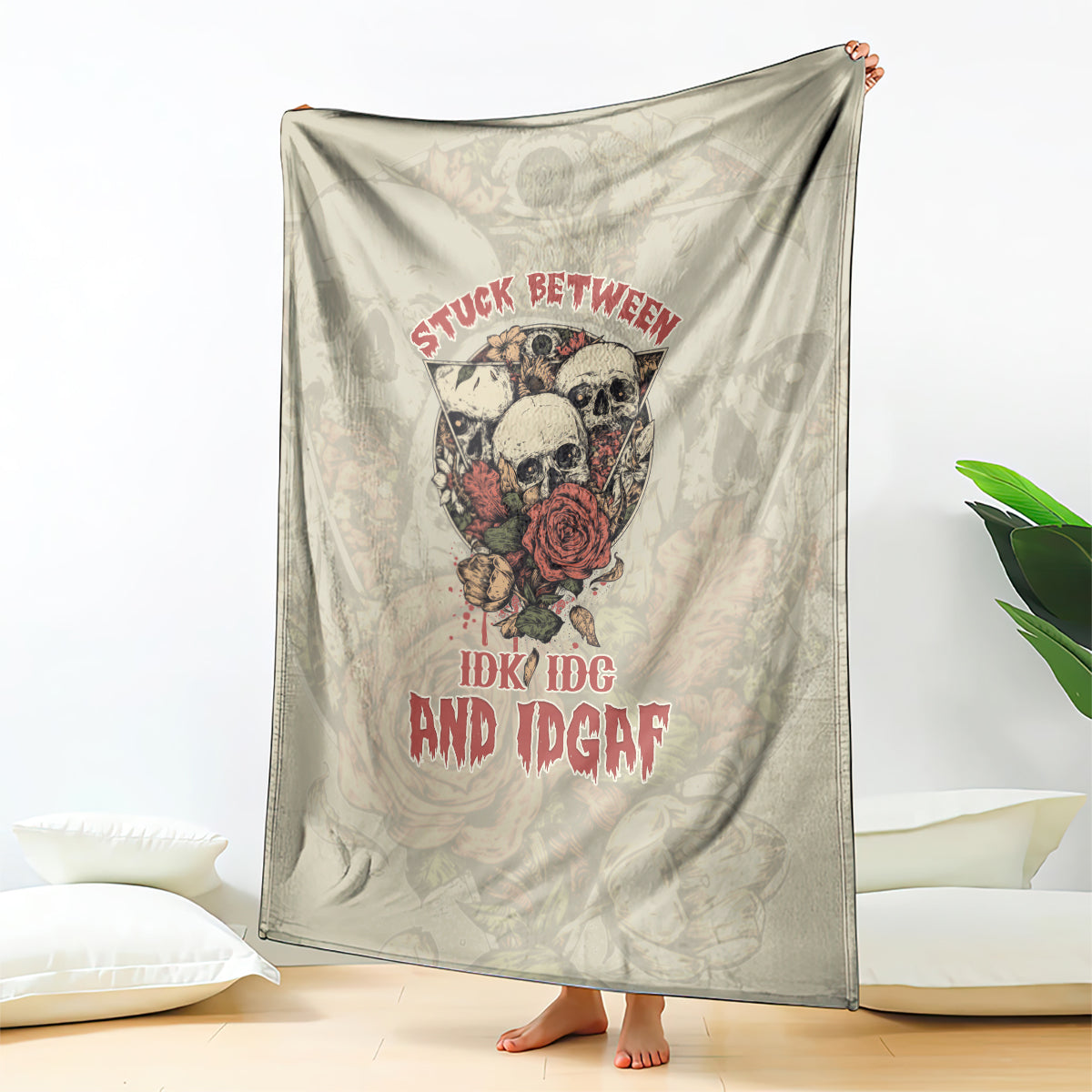 Beige skull blanket draped vertically with red rose and slogan text