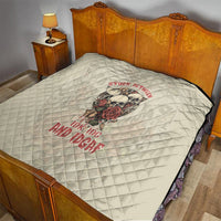 Cream bed quilt with skull graphic and red text, diamond quilted surface