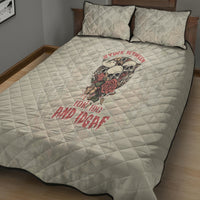 White quilt bed set with skull and rose graphic on quilted cover, two matching pillows.