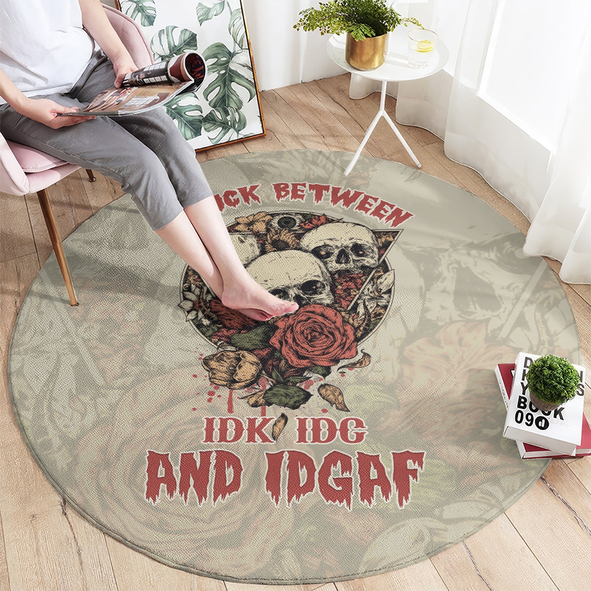 Round area rug with skull and rose graphic, red lettering on light gray background