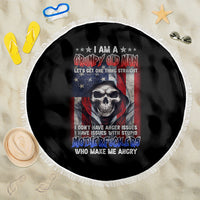 Round black beach blanket showing skull graphic and stars-and-stripes center, white fringe