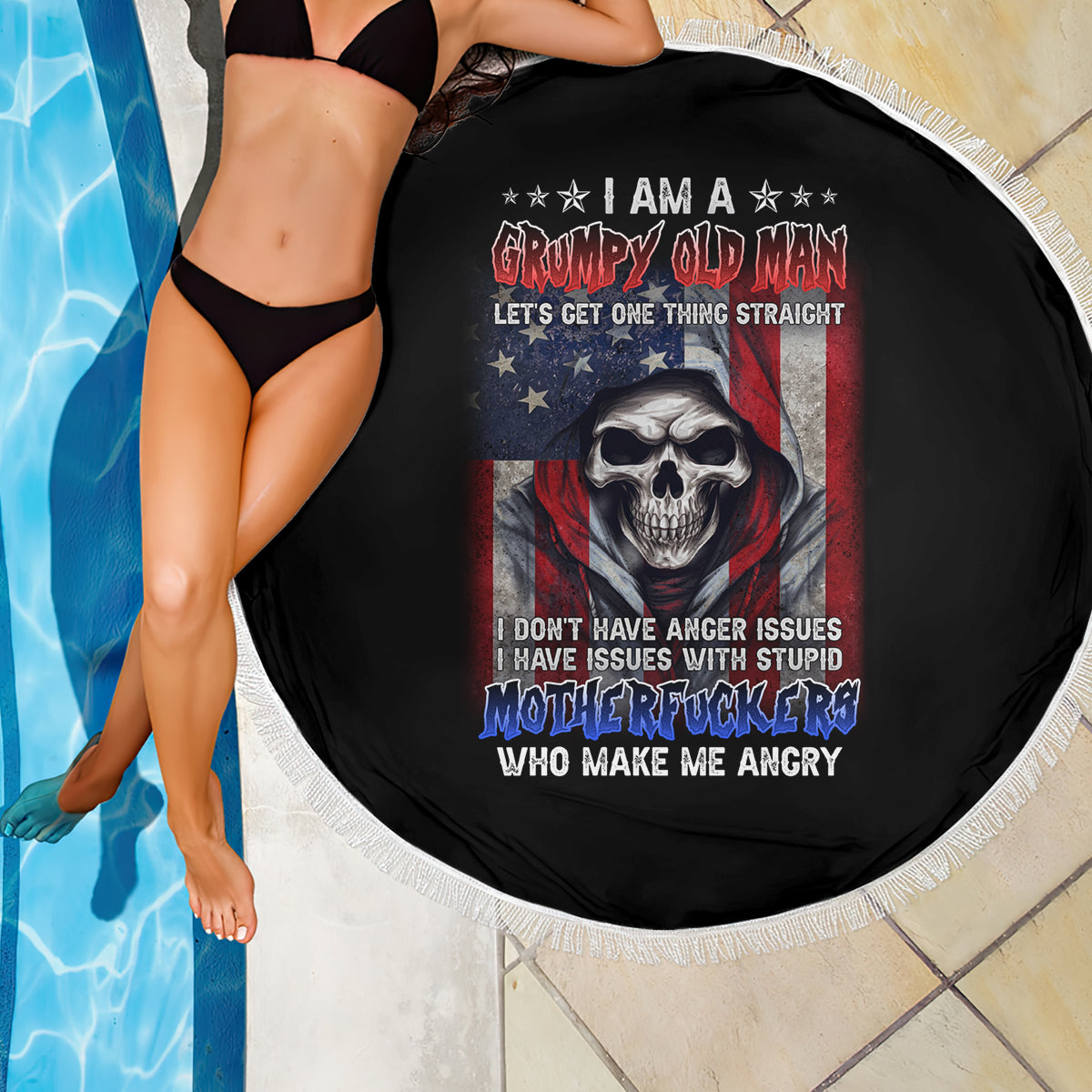 Round black beach blanket with skull graphic and stars-and-stripes design, white fringe border