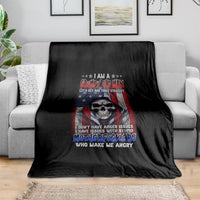Black graphic throw blanket with skull and patriotic slogan design, on a living room sofa