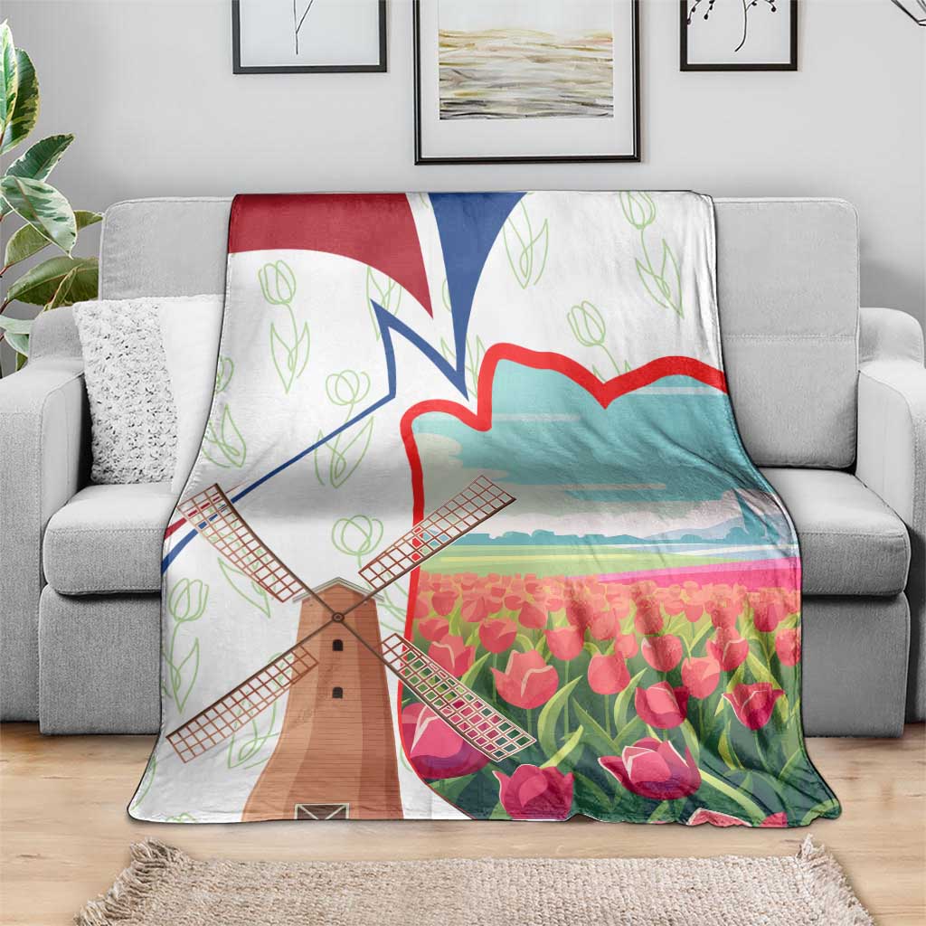 Multicolor Dutch windmill and tulip throw blanket draped over gray sofa