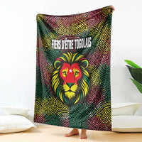 Multicolor Togo blanket with lion head and swirl motifs, French slogan across top