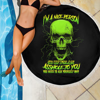 Round black beach blanket with neon green skull print and white fringe beside pool