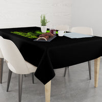 Black skull tablecloth with neon green graphic, hanging over the edge of a dining table