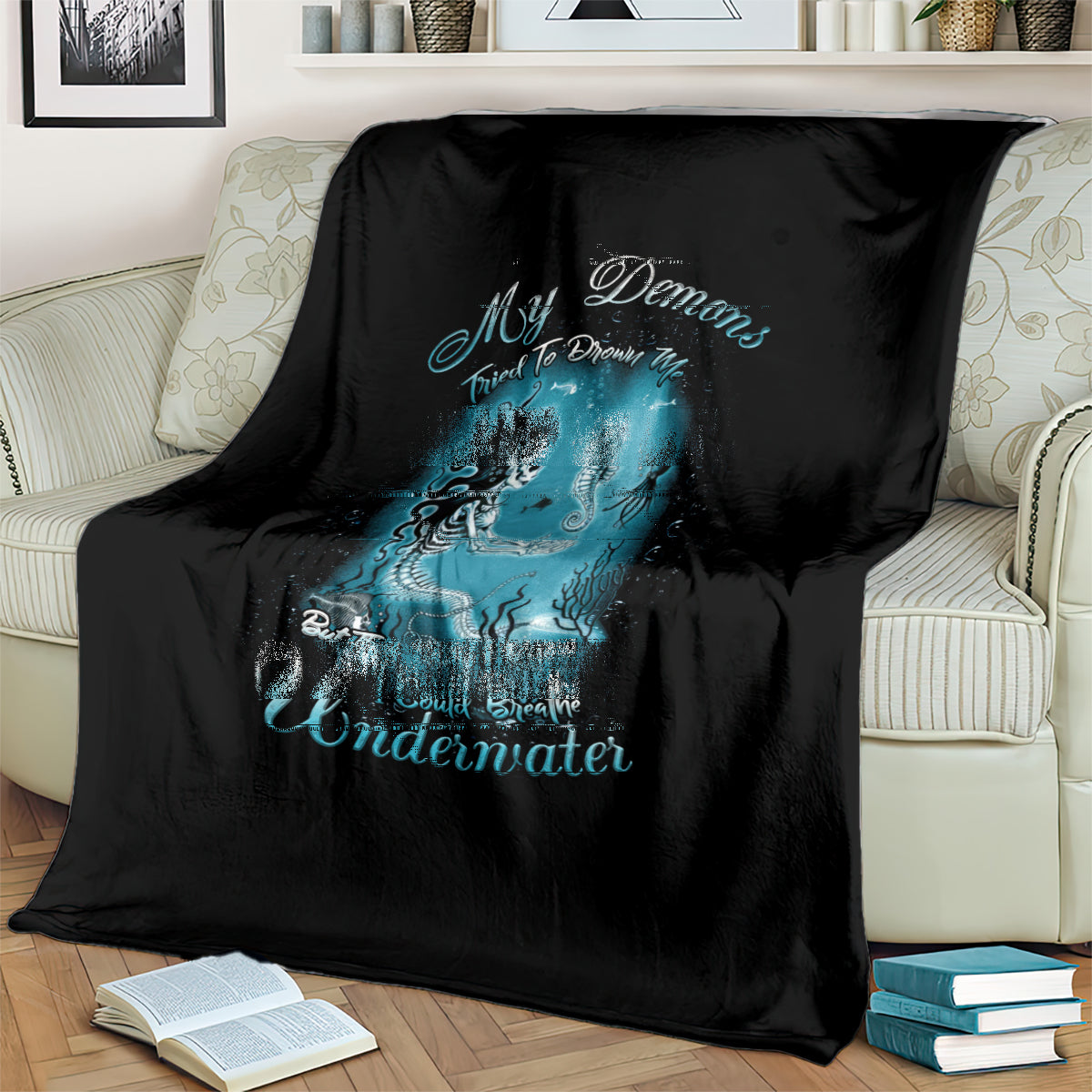 Black mermaid graphic blanket draped on sofa, teal undersea creature print