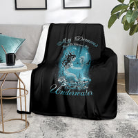 Black mermaid graphic blanket on couch with teal blue undersea creature print