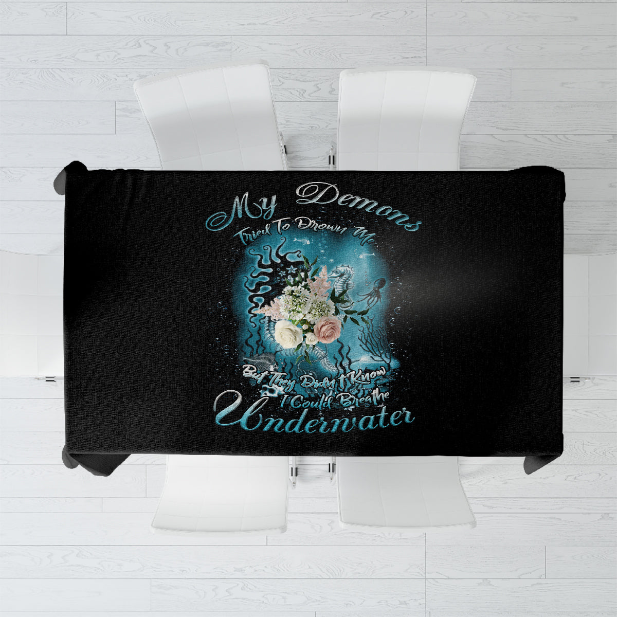 Black tablecloth with centered mermaid illustration and blue decorative text graphic