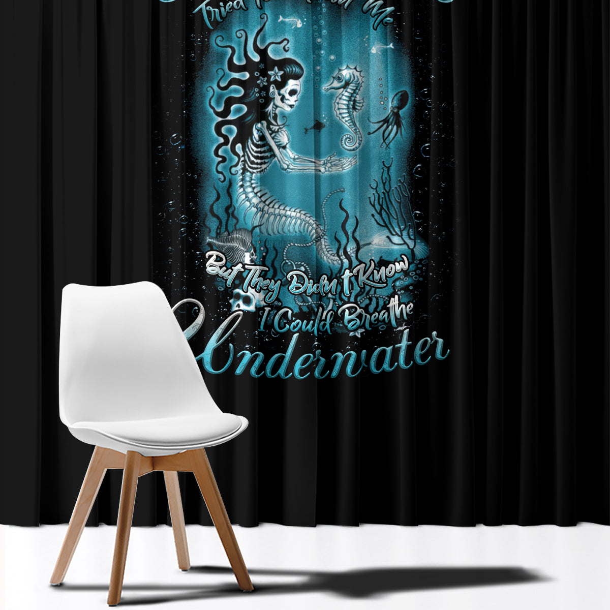 Black window curtain with teal mermaid graphic, hanging folds and full-length coverage