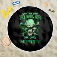 Round black beach blanket with green skull print, neon text, and white fringe border