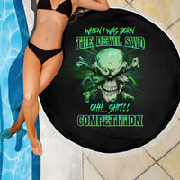 Round black beach blanket with green skull graphic and neon text, white fringe border, partial