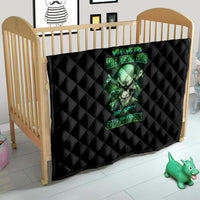 Black quilt blanket on a wooden crib with green skull graphic and neon lettering.