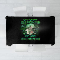 Black printed tablecloth laid flat with green skull graphic and text in center.