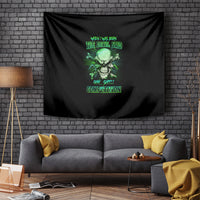 Black skull tapestry with green devil-theme graphic, hung above a gray sofa.