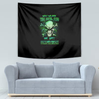 Black skull tapestry with green graphic, hung behind a light-gray sofa.
