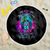 Round black beach blanket with colorful skull floral graphic and white braided fringe border