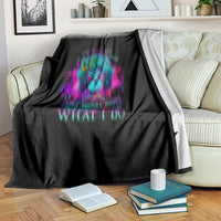 Black fleece blanket with blue and purple skull print and “What I Do” text, draped.