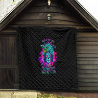 Black quilt with diamond pattern and neon skull graphic displayed on exterior wall