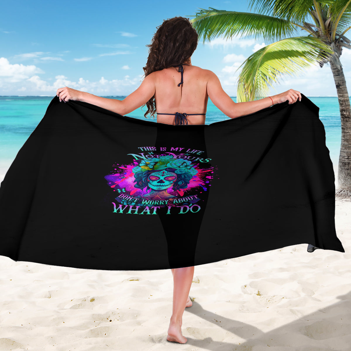 Black sarong with colorful skull graphic and text design, draped wide for coverage.