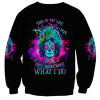 Unisex black crewneck sweatshirt with colorful skull graphic and slogan text on back