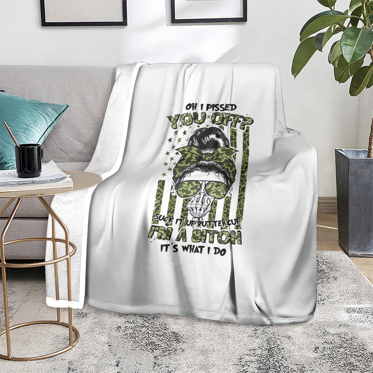 White fleece blanket with green-and-black skull graphic and text, shown on couch
