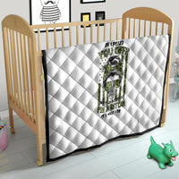 White quilt with diamond quilting and green/black character graphic for crib