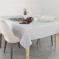 Light gray tablecloth covering a dining table with a neatly draped corner edge.