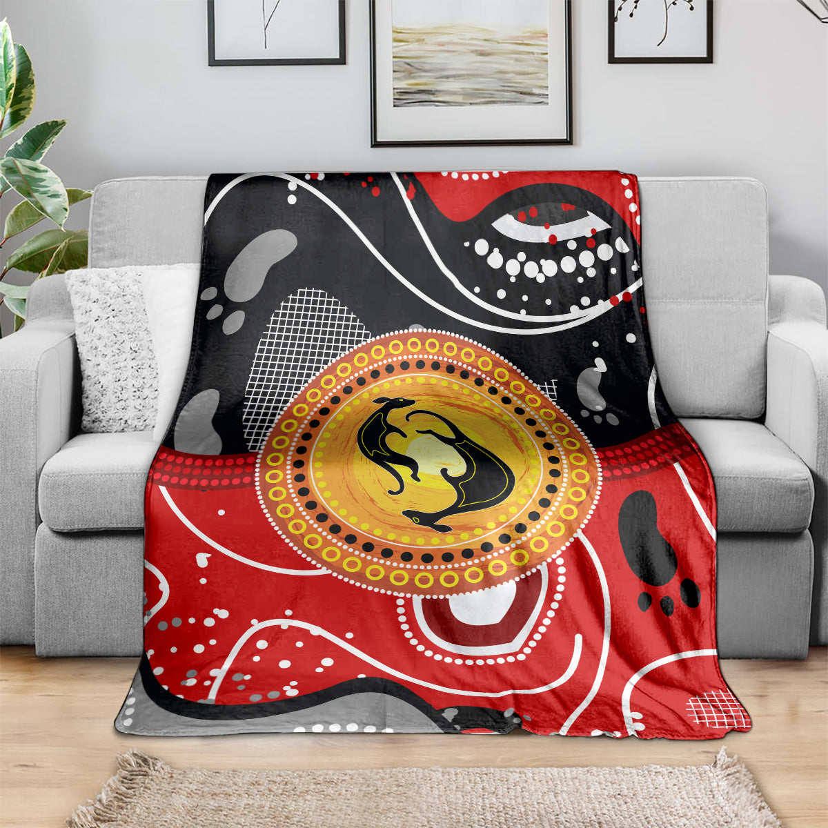 Abstract dot art kangaroo blanket in red and black with yellow center circle on sofa