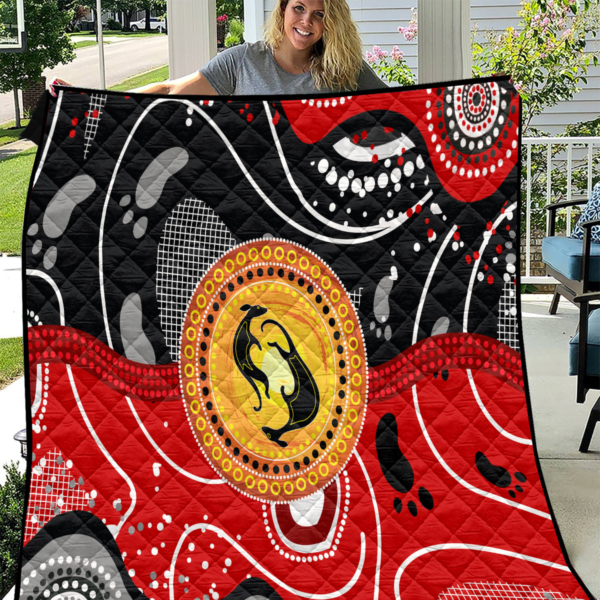 Multicolor quilt with black base, red accents, and central kangaroo dot-art medallion