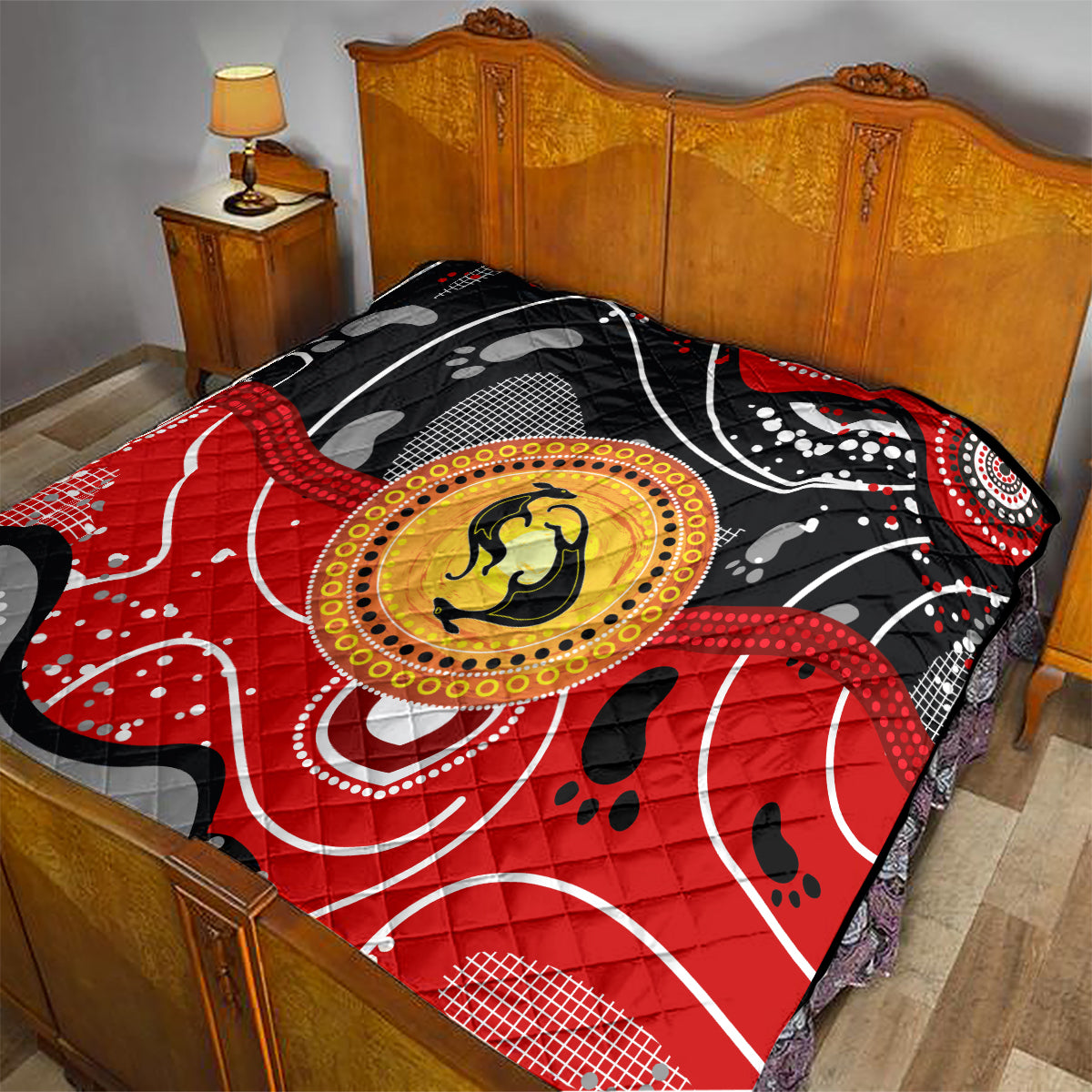 Multicolor quilt on a bed with black and red pattern and a golden kangaroo medallion