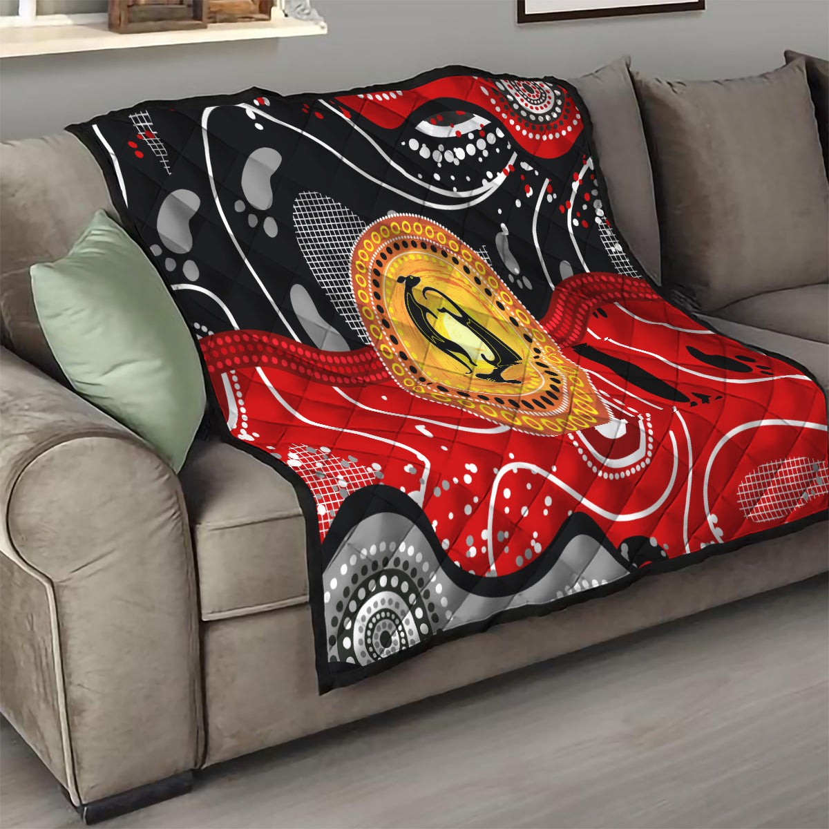 Multicolor quilt on a sofa with black base, red wave design, and round kangaroo dot medallion