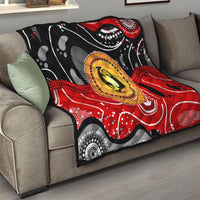 Multicolor quilt on a sofa with black base, red wave design, and round kangaroo dot medallion