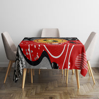 Red abstract tablecloth with black shapes, white lines, and a round dot-art center
