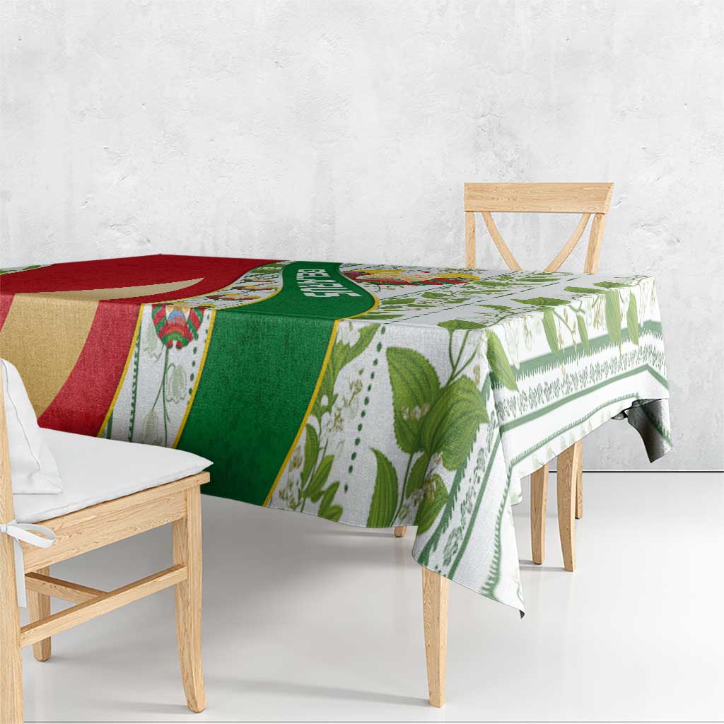Multicolor tablecloth featuring green and red paneling, leaf prints, and central emblem