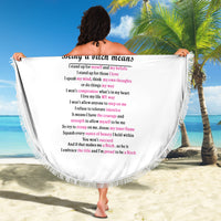 Round beach blanket with pink text and skull roses graphic on white cloth, fringed edge