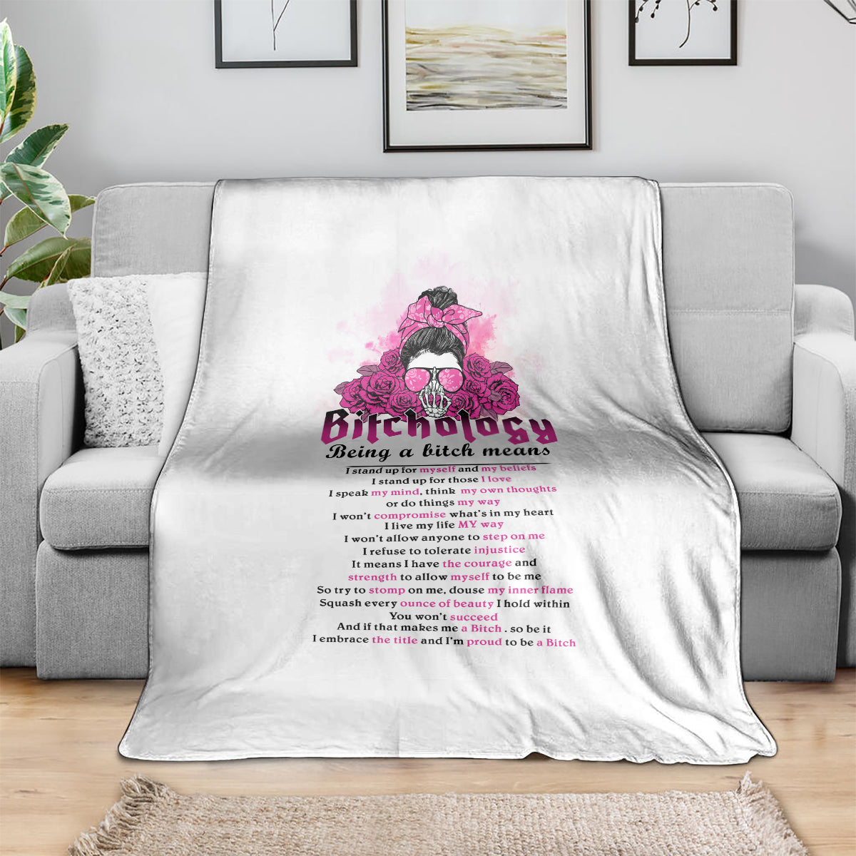 White throw blanket draped over sofa, with pink graphic and readable slogan text