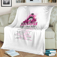 White throw blanket spread on a couch back, showing pink graphic and quote text