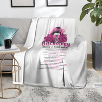 White throw blanket laid on a chair, with pink head graphic and slogan text