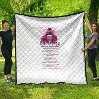 White quilt with diamond stitch and pink graphic text design, held outdoors