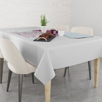 Gray tablecloth draped on dining table with multicolor printed stripe detail