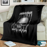 Black throw blanket close-up with faded skull graphic and 'UNDERSTIMATE ME' text