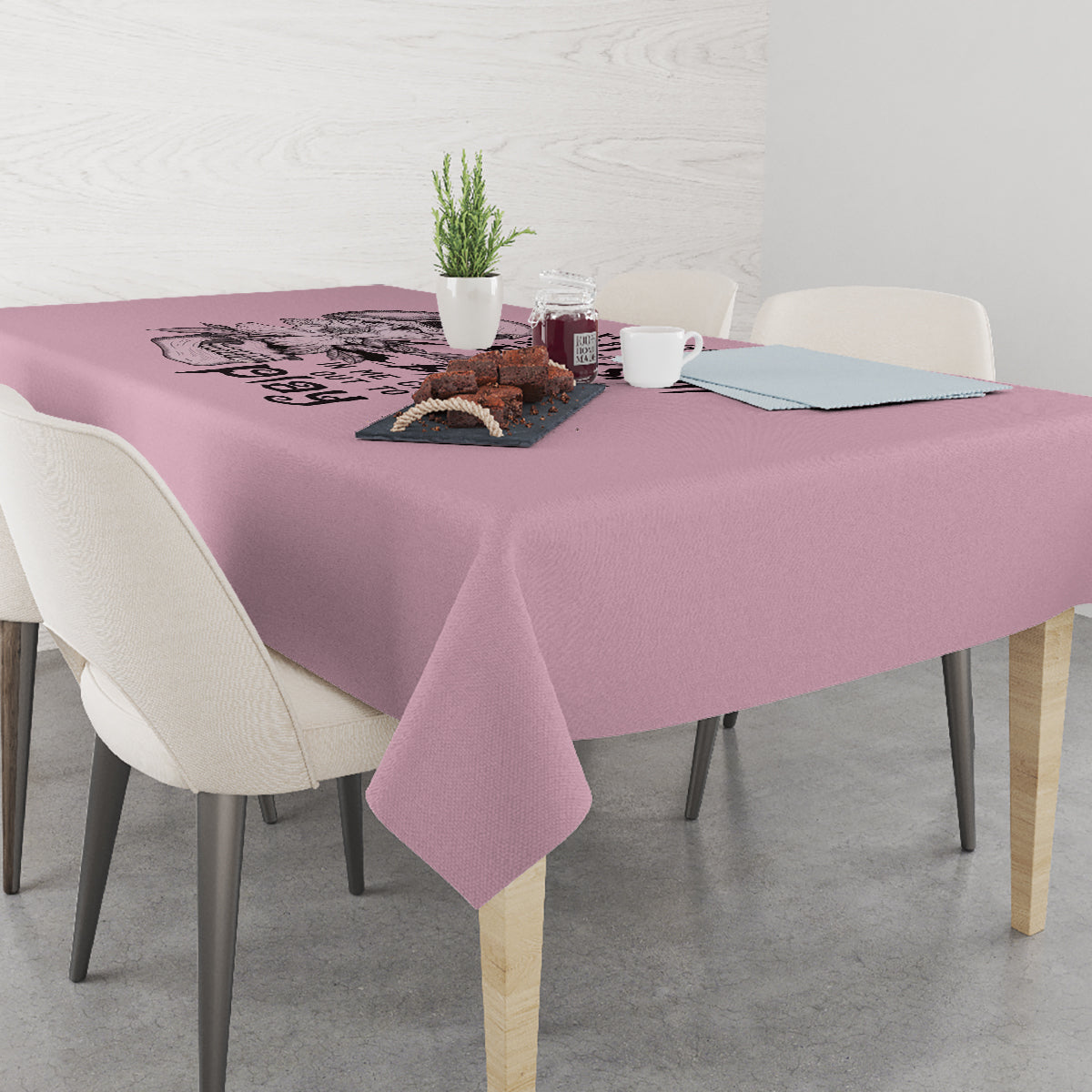 Mauve tablecloth with skull motif across the surface, draped on dining table