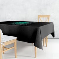 Black tablecloth with teal floral quote graphic, draped over dining table corner